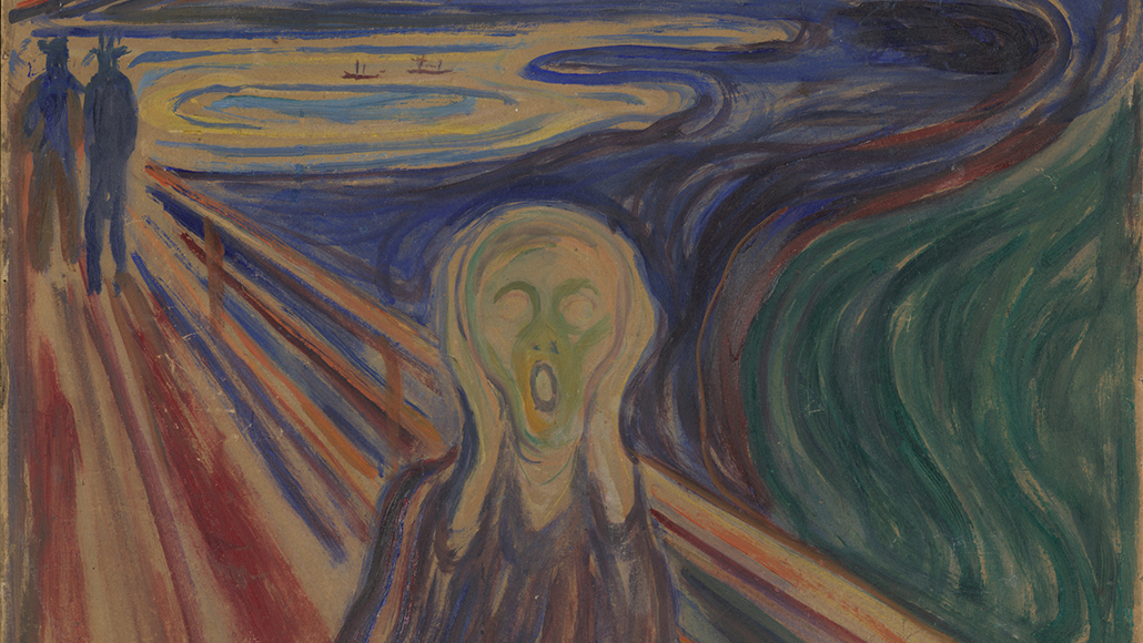 a photo of one of the four "The Scream" paintings by Edvard Munch. A figure faces viewer, with a wide mouth and hands placed on its cheeks. Behind the black-clothed figure, is an orange and red sky.  In the background, two additional figures face sunset. They seem to be on a bridge boardwalk overlooking a cliff and a body of water