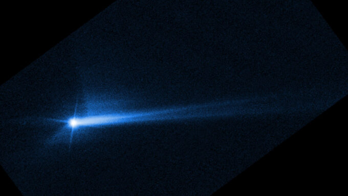 A blue split stream of dust and rock wafting off the asteroid Dimorphos seen after the DART spacecraft mission