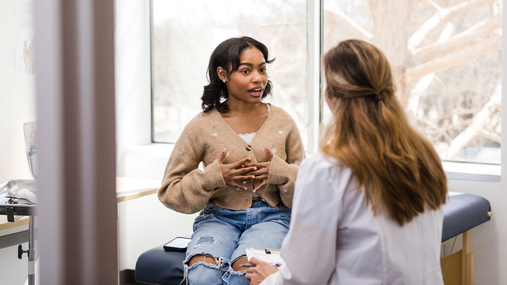 a teen girl speaking with a doctor in a clinic