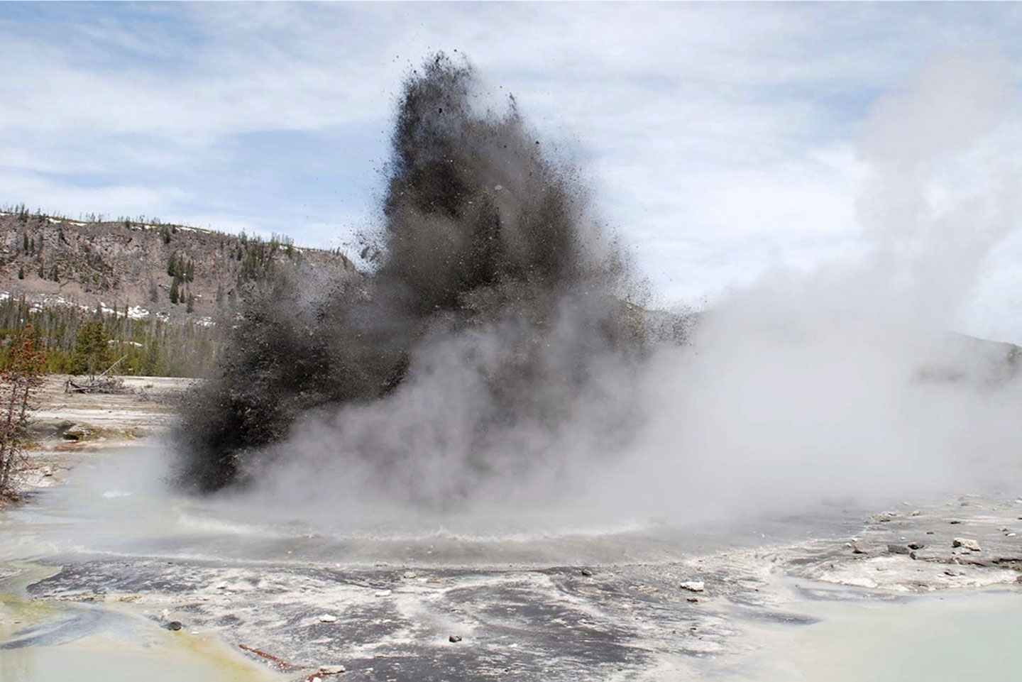 a photo an explosion tossing dsteam and gravel hundresds of feet into the air