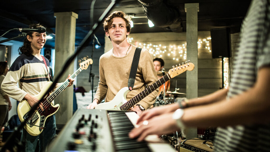 Young rock band rehearsing together and laughing