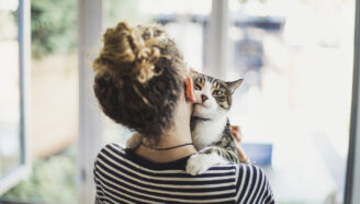 a cat looking over the shoulder of it's owner, a teen girl