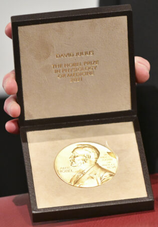 IRVINE, CALIFORNIA - DECEMBER 08: David Julius poses with his medal after receiving Nobel Prize in Physiology or Medicine 'for their discoveries of receptors for temperature and touch,' on December 08, 2021 in Irvine, California. Due to the Covid-19 pandemic, the medal ceremony took place locally instead of the usual ceremony in Stockholm, Sweden. (Photo by Rodin Eckenroth/Getty Images)