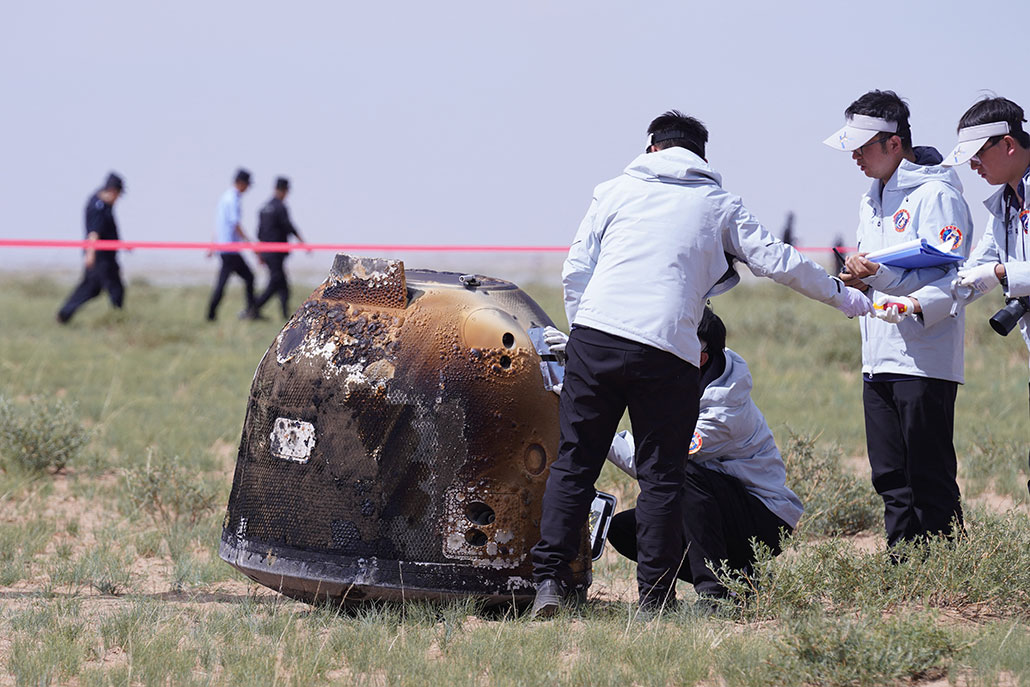 a photo of researchers examining the capsule from the Chang'e-6 probe. 