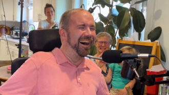 a photo of a man sitting in front of a microphone with a look of joy