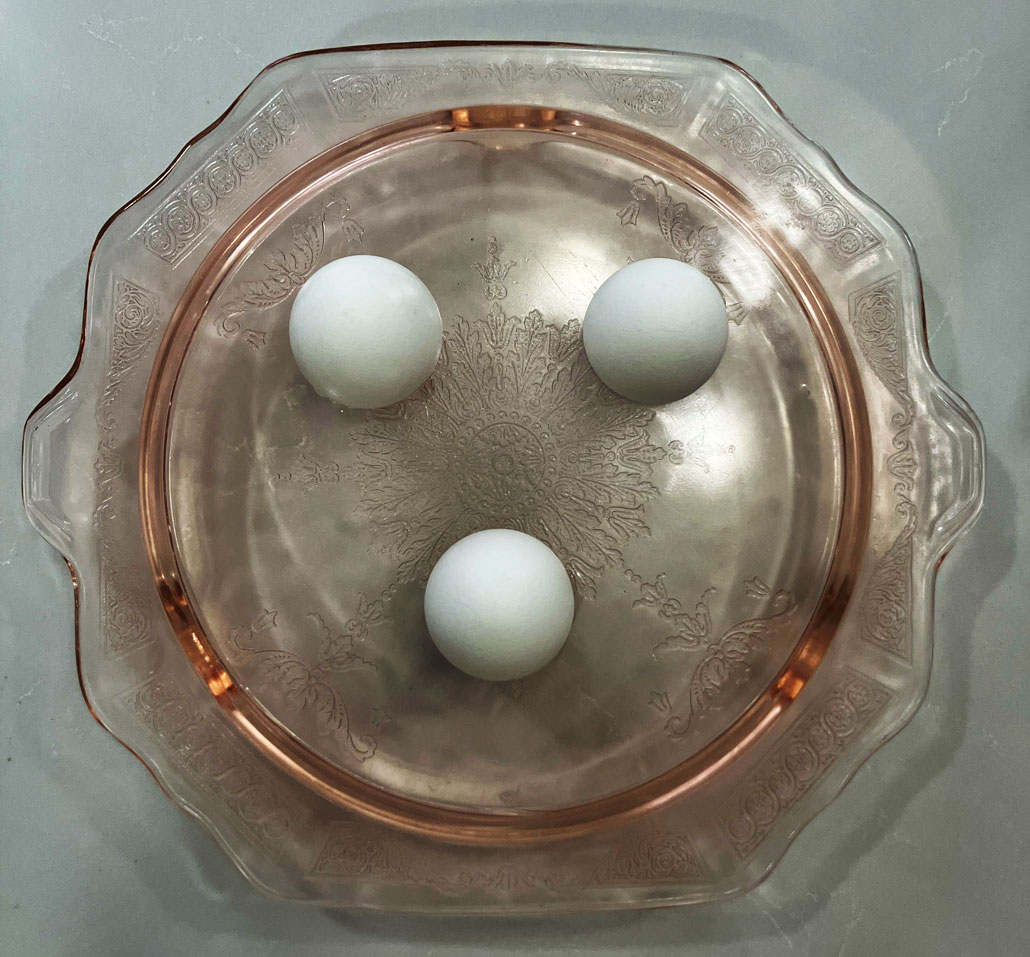 three eggshells are placed, open end down, in a triangle on a plate