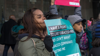 A crowd of young people holding signs, including one saying "I have a right to live tobacco free"