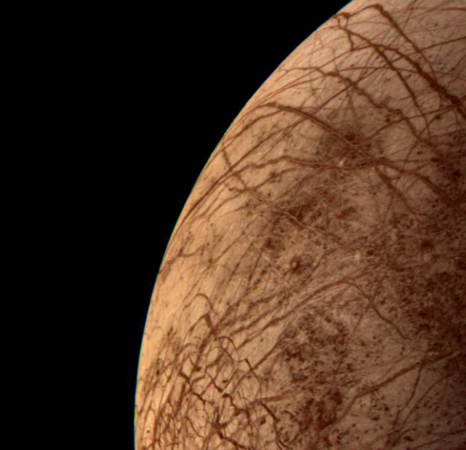 a closeup view of Europa, a brown sphere streaked with darker brown lines. Europa takes up a little less than half the image, and is only a partial view