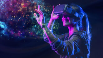 a digitally enhanced photo of a young woman with a ponytail wearing a virtual reality headset smiling and reaching out towards abstract shapes in front of her